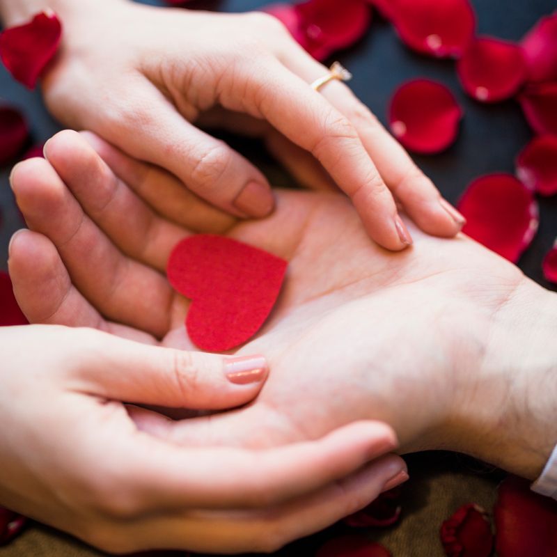 Zwei Handpaare halten ein Herz in der Hand