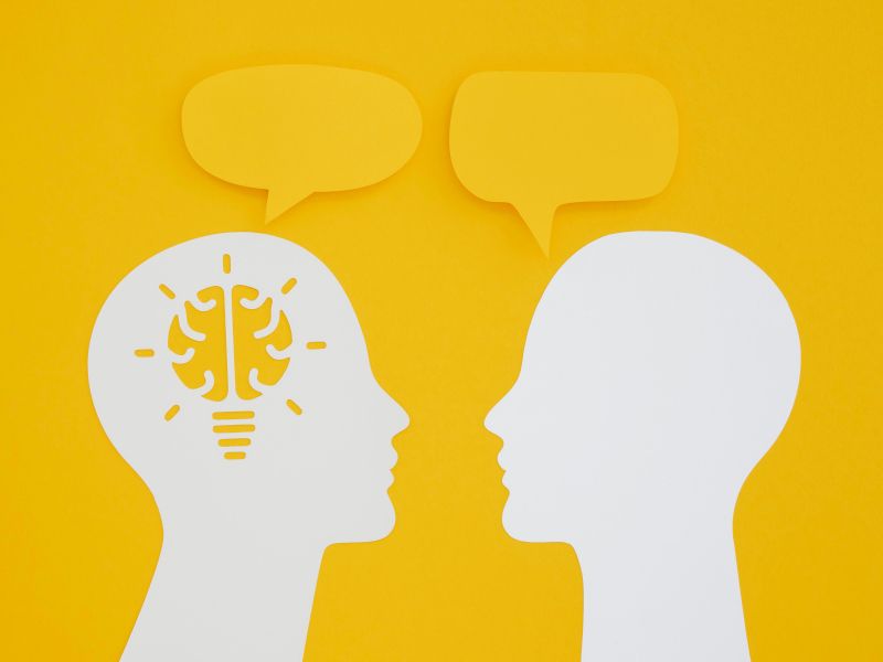 Zwei Köpfe mit Sprechblasen zur Kommunikation