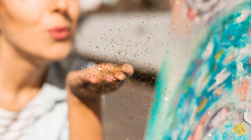 Künstlerin bläst pigmente auf Bild